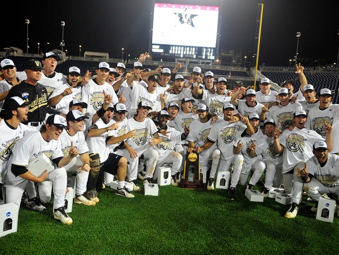 Vanderbilt coaches and players have their team photo taken with a trophy after defeating Virginia 3-2 at the College World Series at TD Ameritrade Park in Omaha, Neb., Wednesday, June 25, 2014.