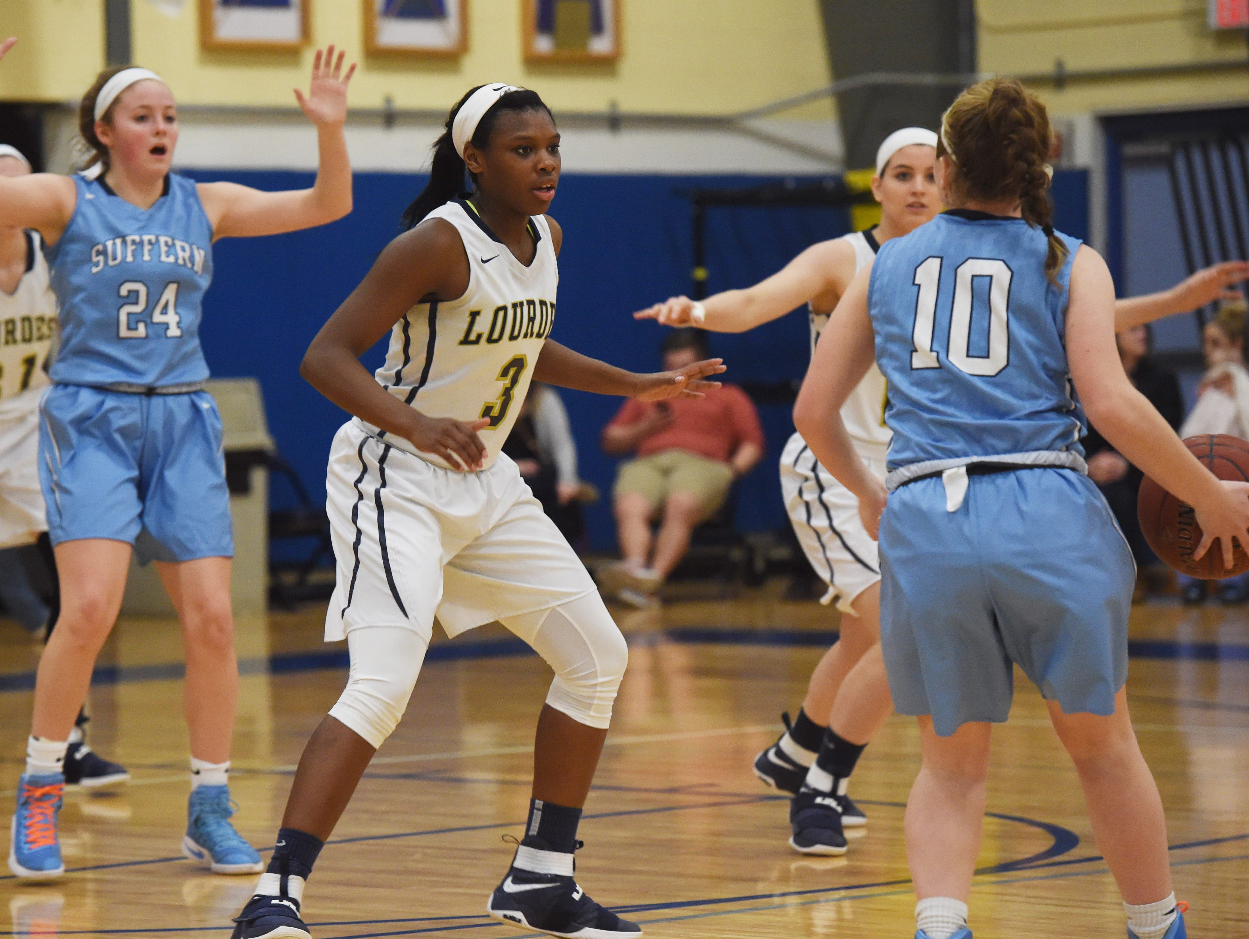 Lourdes' Rebecca Townes, left, defends while Suffern's Grace Krebs, right, heads towards the basket during Friday's game.