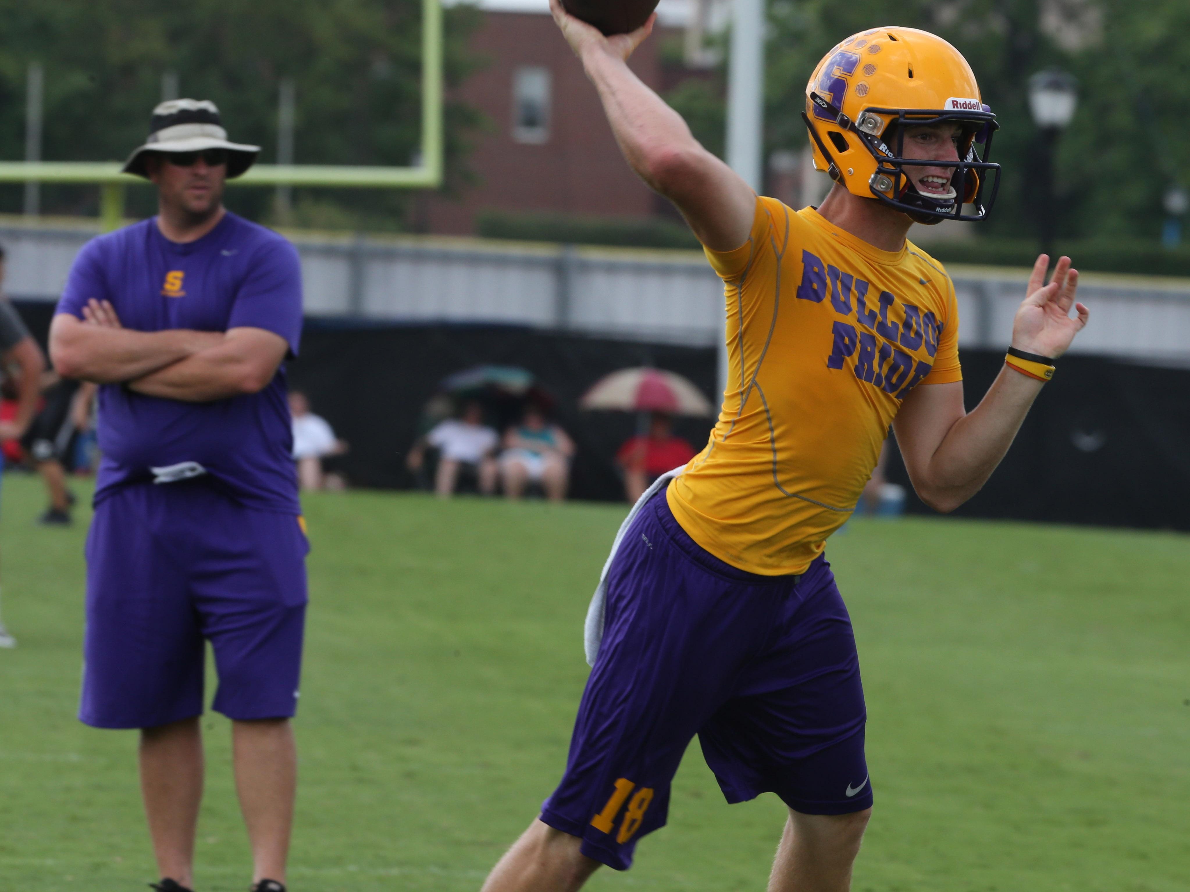 Smyrna quarterback John Turner throws a pass as coach Matt Williams watches.