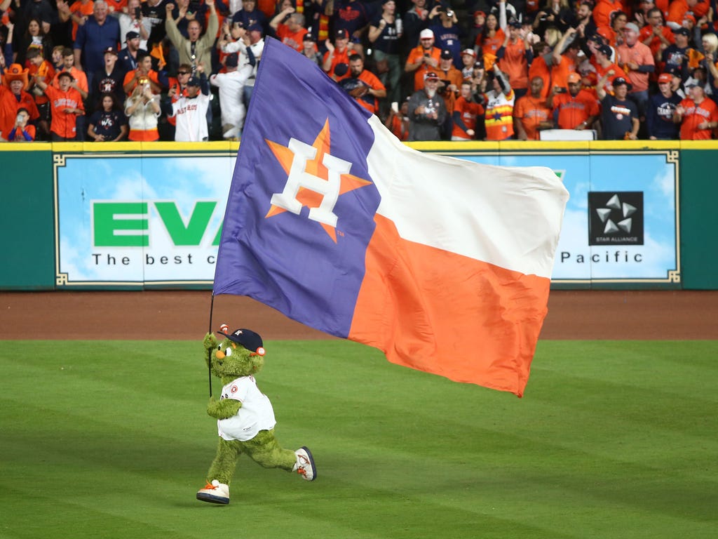 The Houston Astros mascot Orbit waves a flag after the Astros defeated the Los Angeles Dodgers, 5-3, in Game 3 of the World Series  at Minute Maid Park.