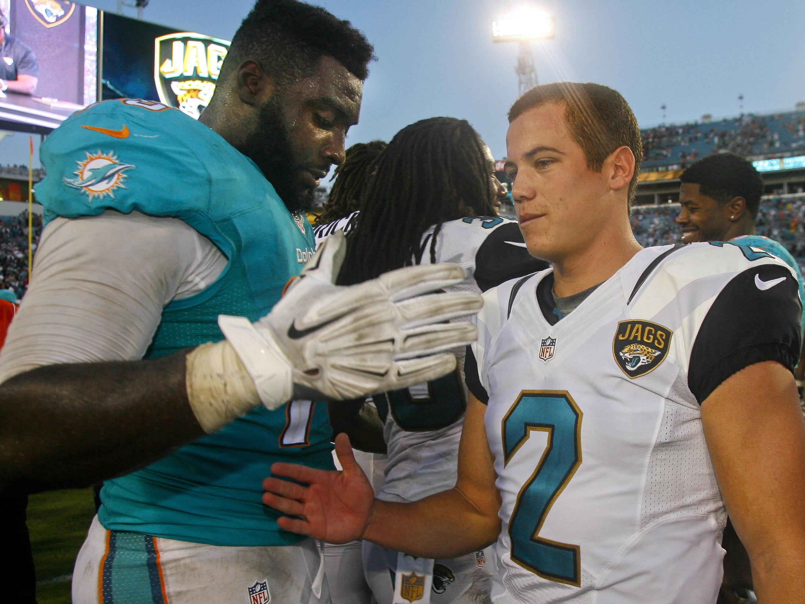 Marist College alumni Terrence Fede of the Miami Dolphins, left, and Jason Myers of the Jacksonville Jaguars, meet on the field after the Jaguars defeated the Dolphins 23-20 on Sept. 20, 2015 in Jacksonville, Florida.