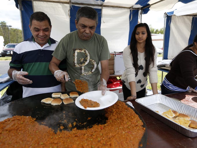 Kalpesh Patel, left Parvin Patel and Rutva Partel serve Pav Bhaji ( a mix of mashed potatoes and vegetables) during the Taste of India at the Hindu Temple of Greater Cincinnati.