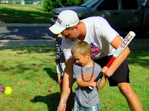 NubAbility founder Sam Kuhnert works with a young boy to teach him baseball. Kuhnert, who was born without his left hand, played two seasons of college baseball as a right-handed pitcher.