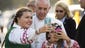 Pope Francis takes a photo with children whose parents
