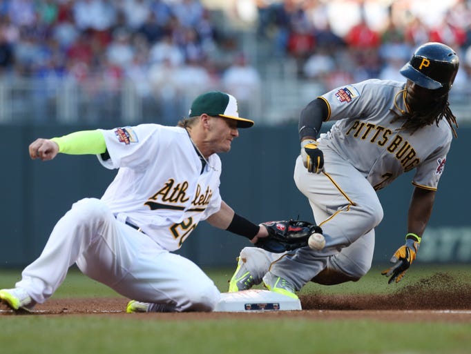 National League outfielder Andrew McCutchen, of the Pittsburgh Pirates, steals third base as American League Josh Donaldson, of the Oakland Athletics, tries to make the tag during the first inning of the MLB All-Star baseball game, Tuesday, July 15, 2014, in Minneapolis. (AP Photo/Jim Mone)