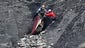 Rescue workers check debris at the crash site near