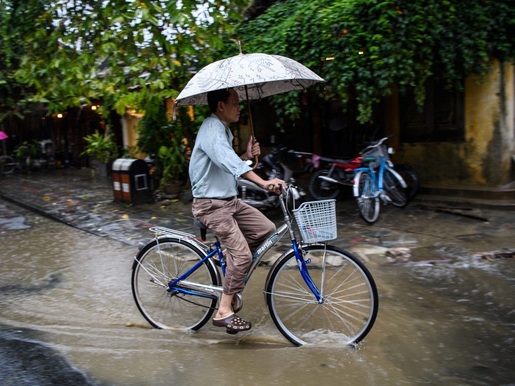 A man rides a bicycle in the town of Hoi following days of heavy rains after Typhoon Damrey hit the coast of Viet Nam.