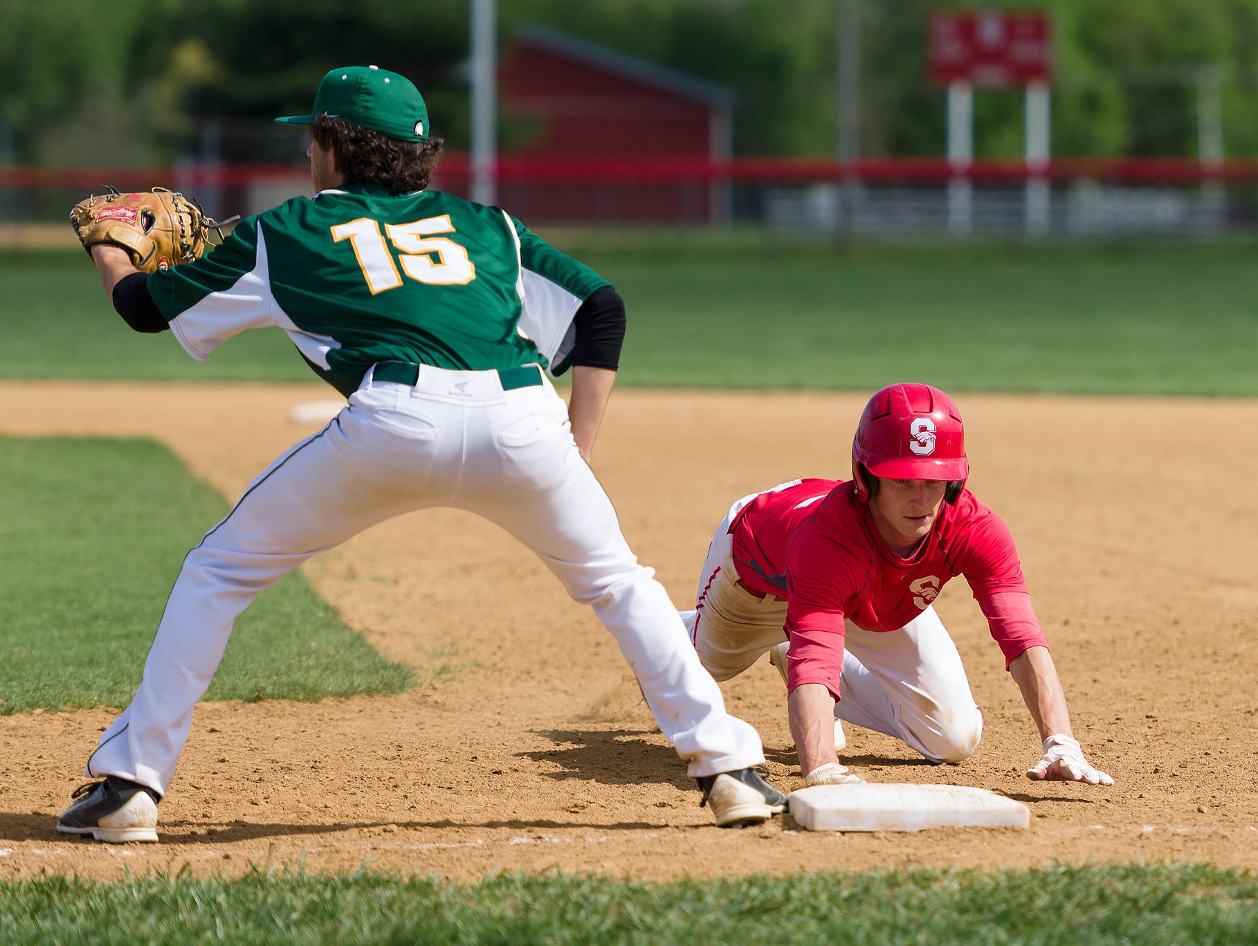 Matthew Theodorakis (15) of St. Mark's misses the tag on Shawn Dulin (2) of Smyrna at first base in a St. Mark's at Smyrna baseball game on Saturday.