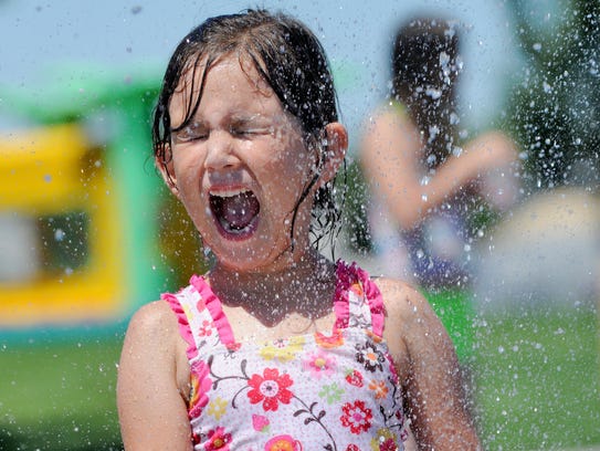 Kayla Holdridge is sprayed with water at Settlers Park