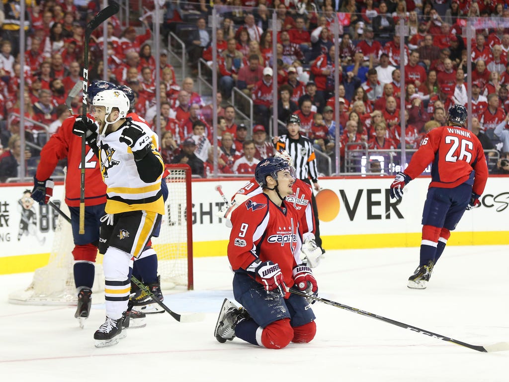 Pittsburgh Penguins right wing Bryan Rust celebrates after scoring a goal past Washington Capitals goalie Braden Holtby as Capitals defenseman Dmitry Orlov looks on during the second period in game seven of the second round of the 2017 Stanley Cup Pl