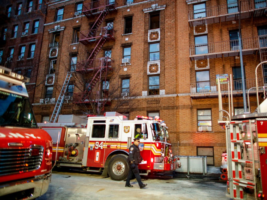A NYPD officer walks on the scene of an apartment fire in the Bronx burough of New York City on Dec. 29, 2017.\u000aOfficials said Friday that the death toll from the fire has reached 12, including four children.