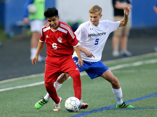 Holmes' Jose Benito de la Cruz takes the ball from