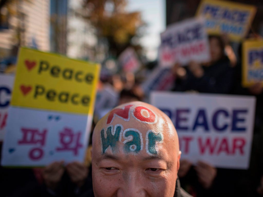 Demostrators hold placards during a peace rally in Seoul on Nov. 5, 2017.\u000d\u000aThousands of South Koreans called for peace in a protest against an upcoming visit by Donald Trump as he begins a two-week Asia tour amid tension over North Korea's 