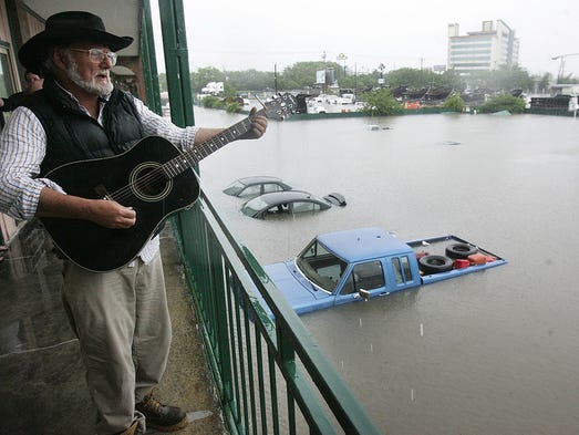 Dover Anthony sings while playing his guitar as he