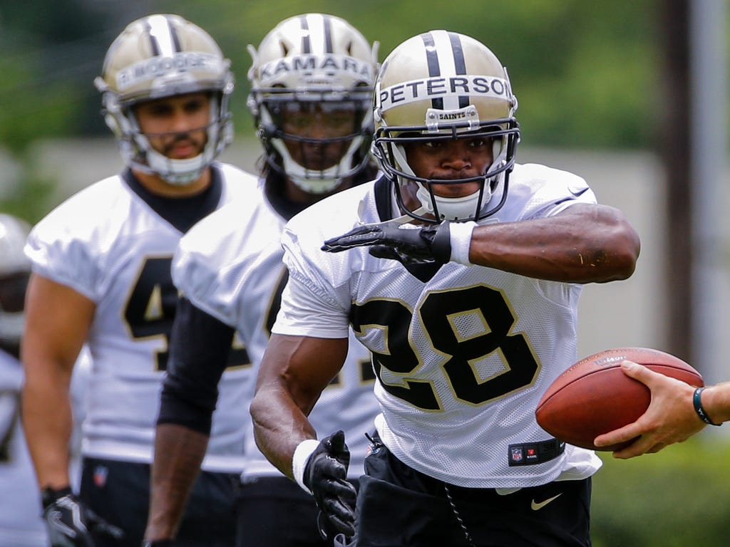 New Orleans Saints running back Adrian Peterson takes a handoff from quarterback Ryan Nassib during a minicamp at the New Orleans Saints Training Facility in New Orleans.