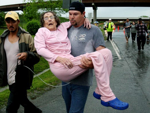 Neighbors help Janie Cramen to an ambulance after she