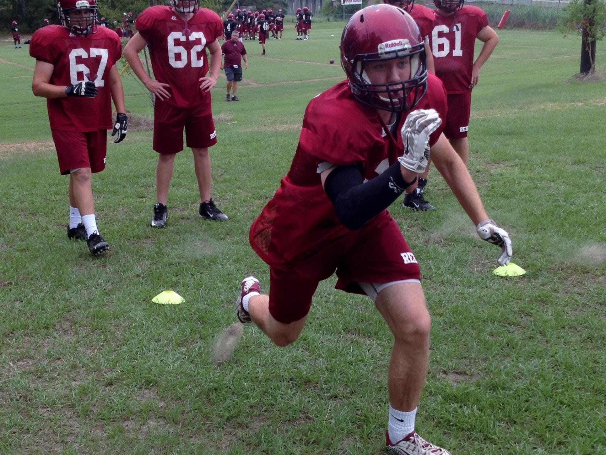Pineville senior right tackle Harrison Nugent (64) runs through a drill during practice Tuesday. The undersized Nugent is one of the top academic and most involved students at Pineville High School.