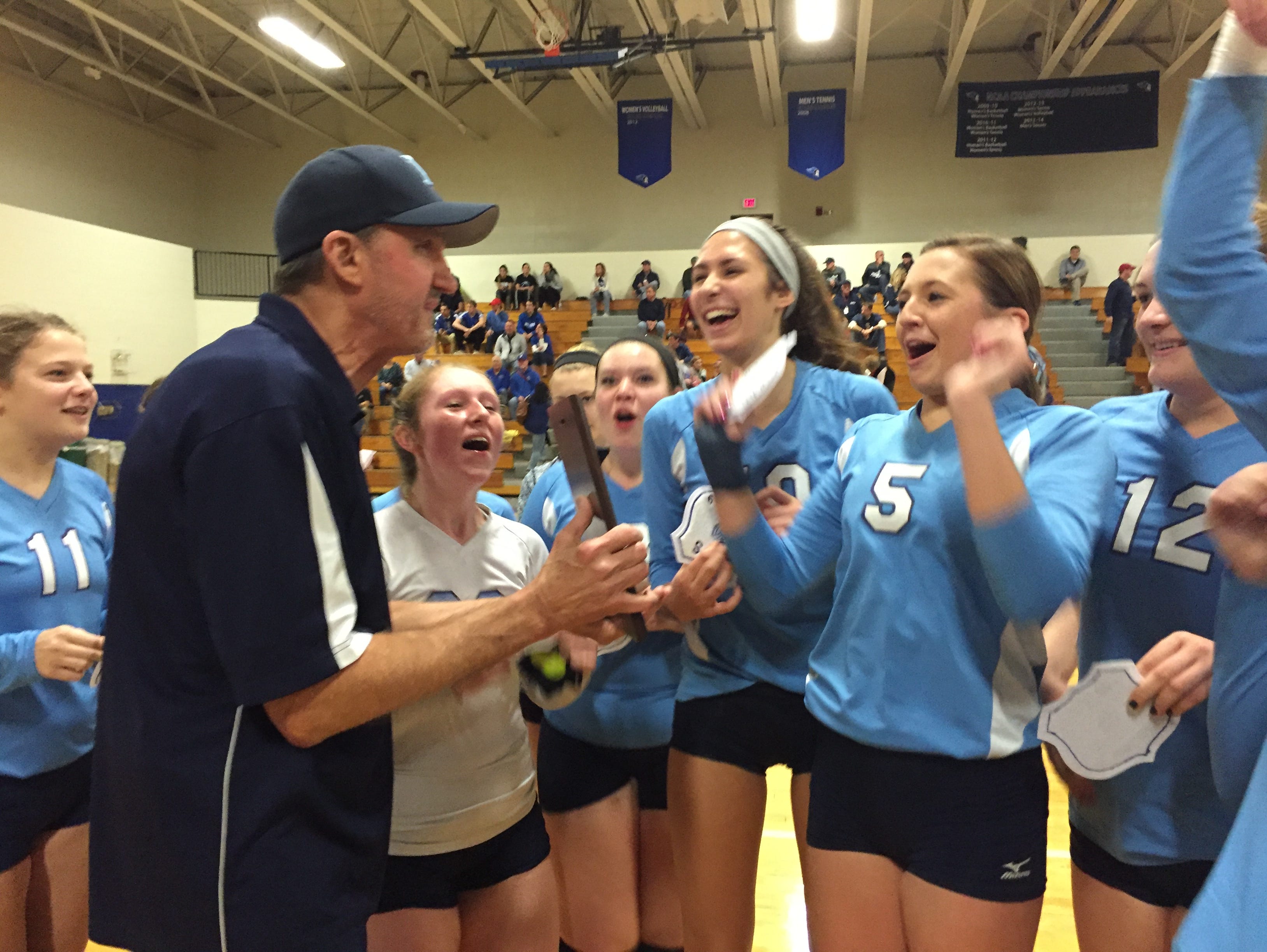 Pine Plains volleyball coach Larry Strickland, left, celebrates with his team after the Bombers won the Section 9 Class D title in Newburgh on Nov. 8, 2015.