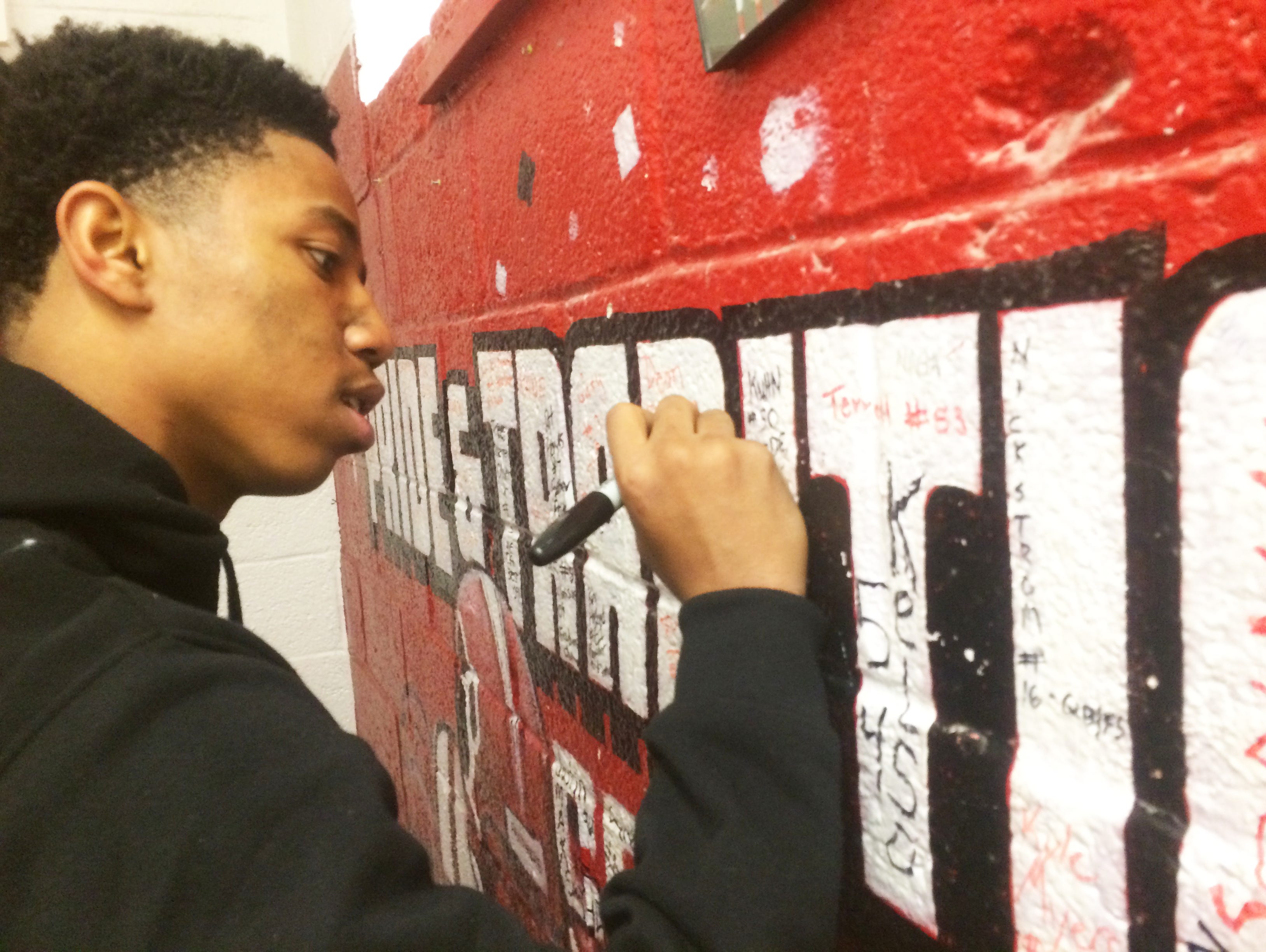 Palmrya High School defensive back/wide receiver Terry Bailey signs his name on the Panthers' locker room wall after the team's Central Jersey Group 1 loss to Shore Regional on Dec. 5.
