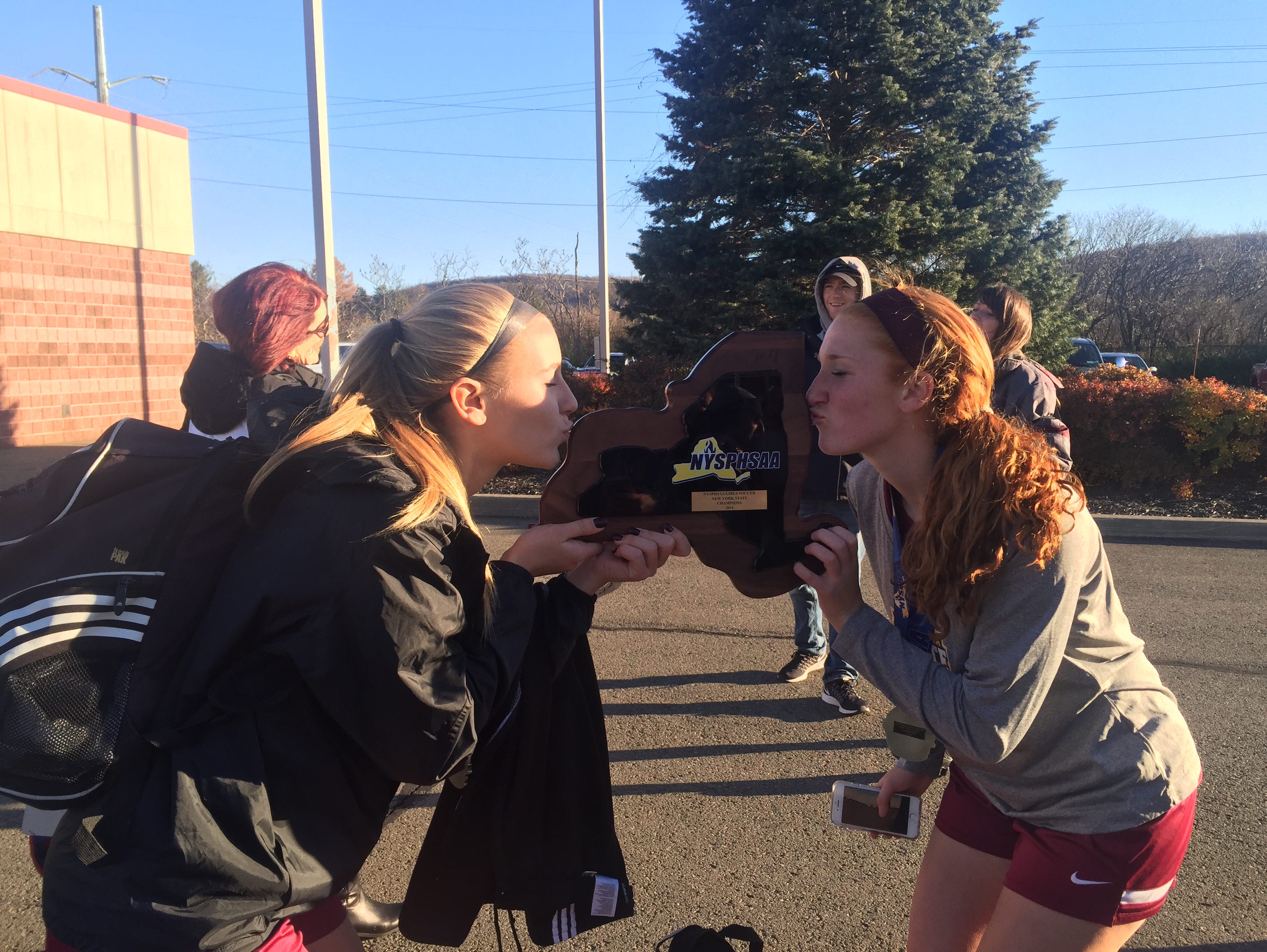 Arlington soccer players Ashley Cross and Abby Carlin kiss the state championship plaque.