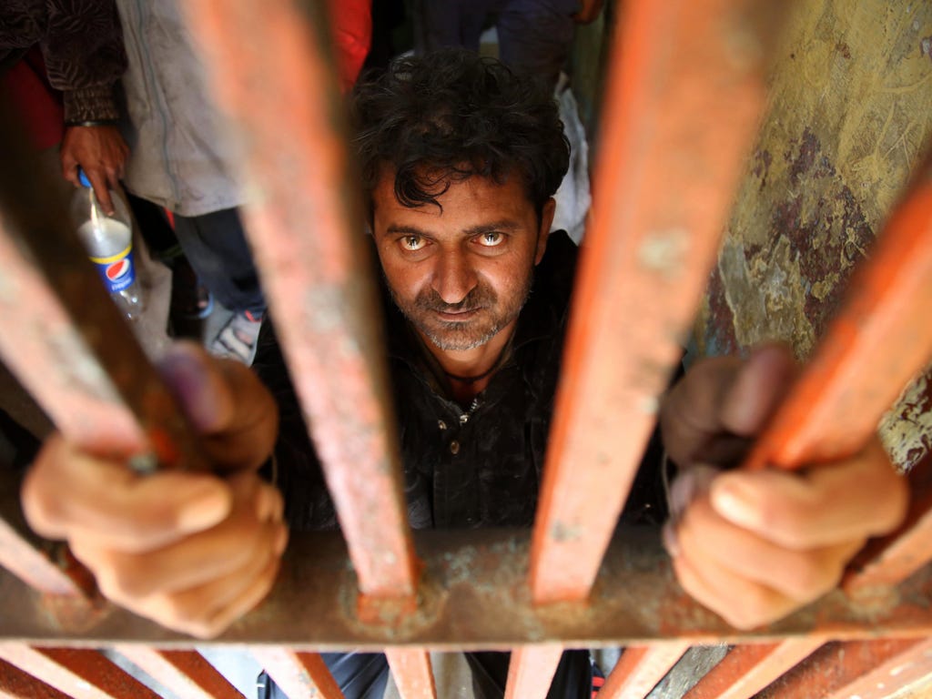 Indian fishermen who were arrested after allegedly straying into Pakistan's territorial waters, sit behind bars at a police station in Karachi, Pakistan. The Pakistani Maritime Security Agency arrested 43 Indian fishermen, took their fishing boat und
