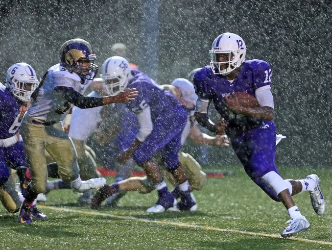 New Rochelle quarterback Greg Powell rushes through the rain for New Rochelle's first touchdown against Clarkstown North at during a varsity football game at New Rochelle Oct. 2, 2015. New Rochelle defeated Clarkstown North 12-6.