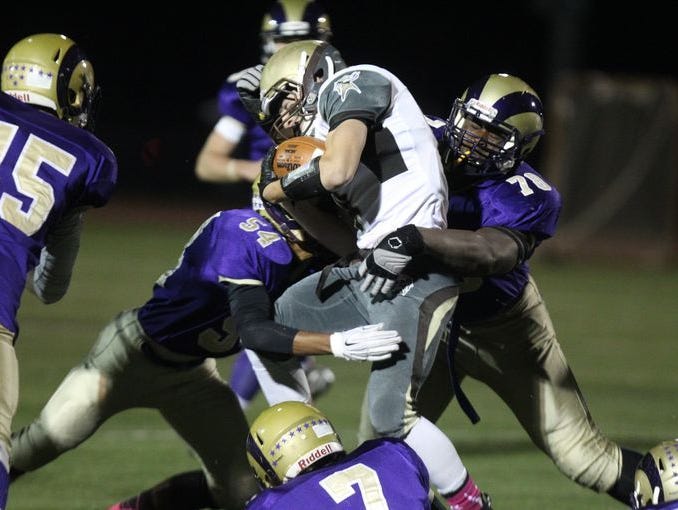 Cameron Conrad (54) and Prince Emili (78) meet at the ball carrier during Clarkstown North's 21-0 defeat of rival Clarkstown South in the Class AA quarterfinals on Oct. 23, 2015.