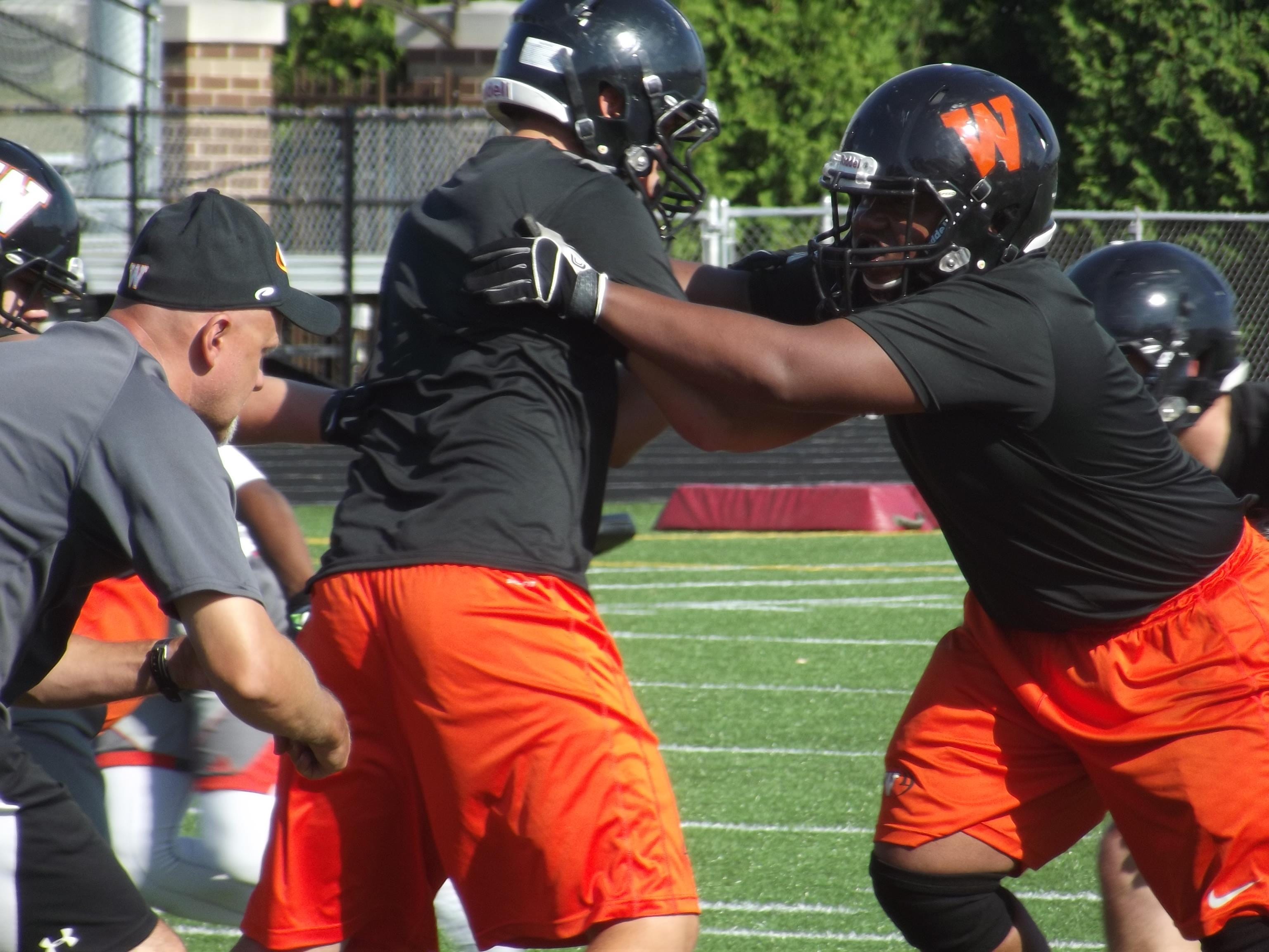West De Pere senior defensive lineman Malcolm Smalls goes through a defensive drill with coach Jack Batten at practice Wednesday.