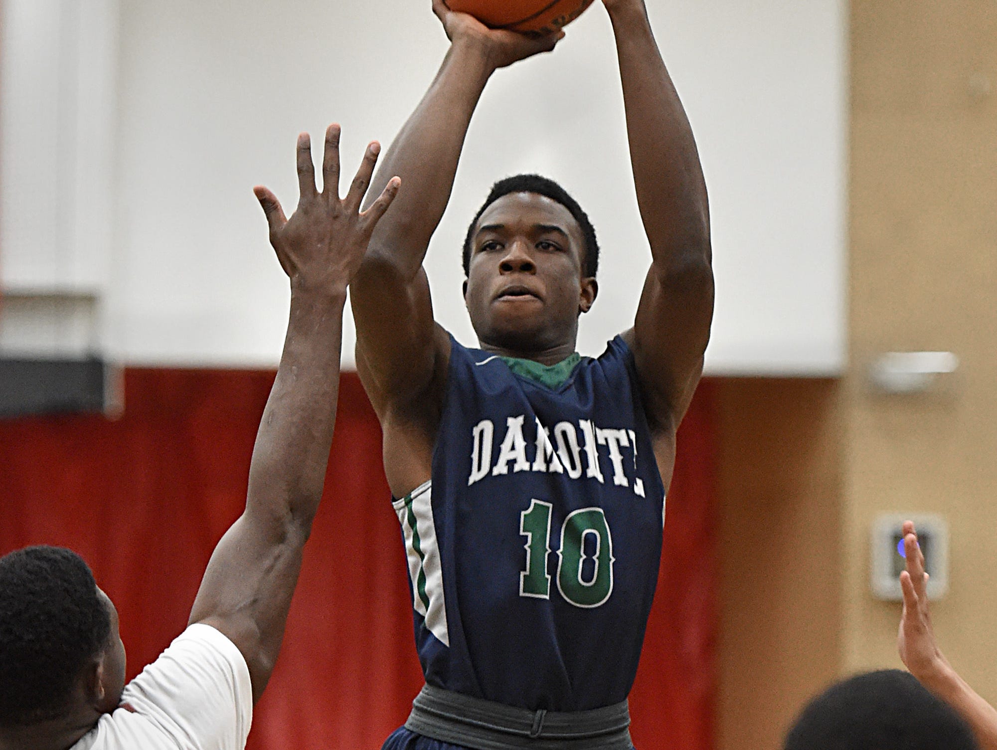 Damontes' Nyaabila Apambire shoots with Wooster Chosen Gbenjo covering him during Tuesday's game at Wooster.