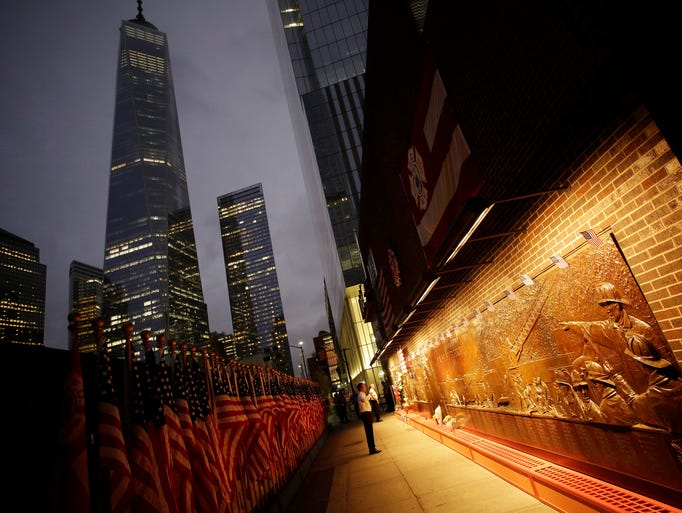A firefighter looks at a memorial mural outside the Engine Company 10 building near the World Trade Center on Sept. 11 in New York. On Sept. 11, 2001, 343 firefighters were killed in the terrorist attacks.