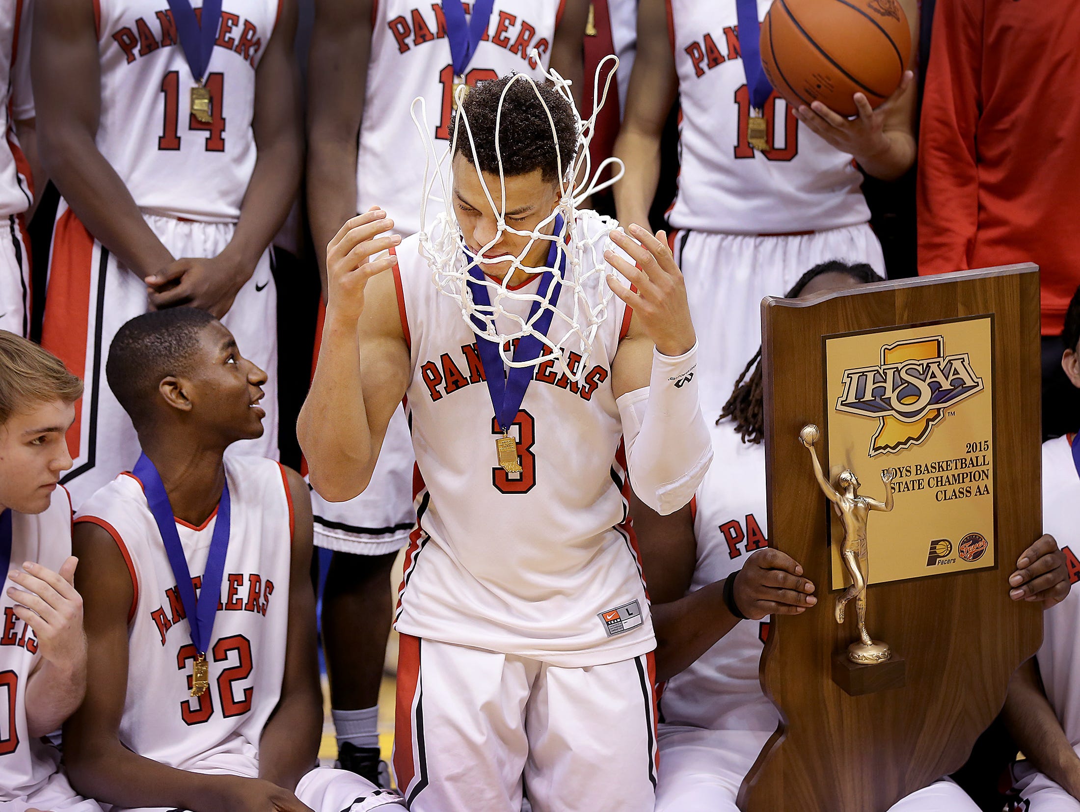 Park Tudor Bryce Moore tosses the net over head as he celebrates with his teammates. The Park Tudor Panther defeated the Frankton Eagles 73-46 to win the IHSAA 2A Boys Basketball State Final Saturday, March 28, 2015, afternoon at Bankers Life Fieldhouse.