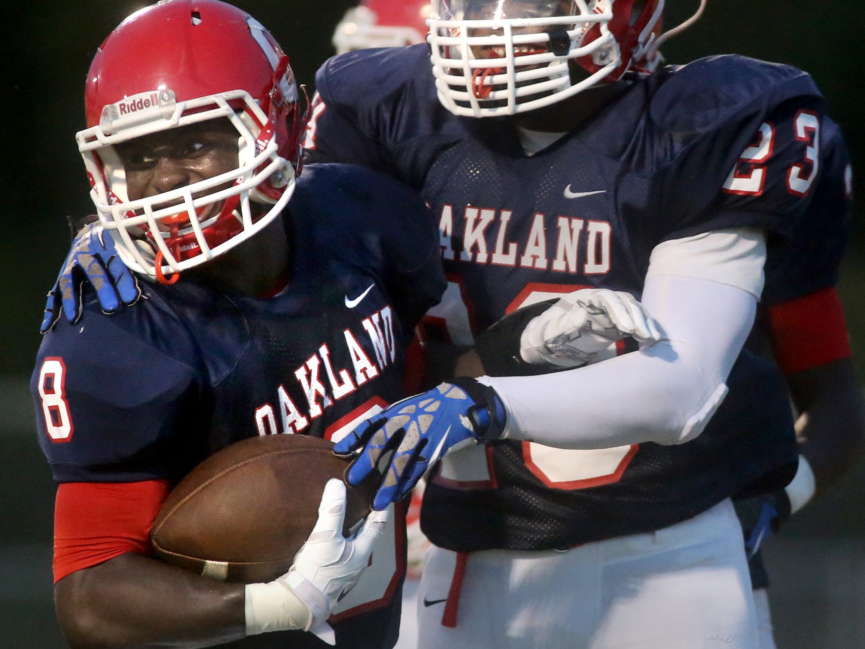 Oakland's George Gbesee is congratulated by teammate Turrel Ward after Gbeseea scored a touchdown from a recovered fumble in the first half of the game against White Station at Oakland, on Friday, August 2, 2014.