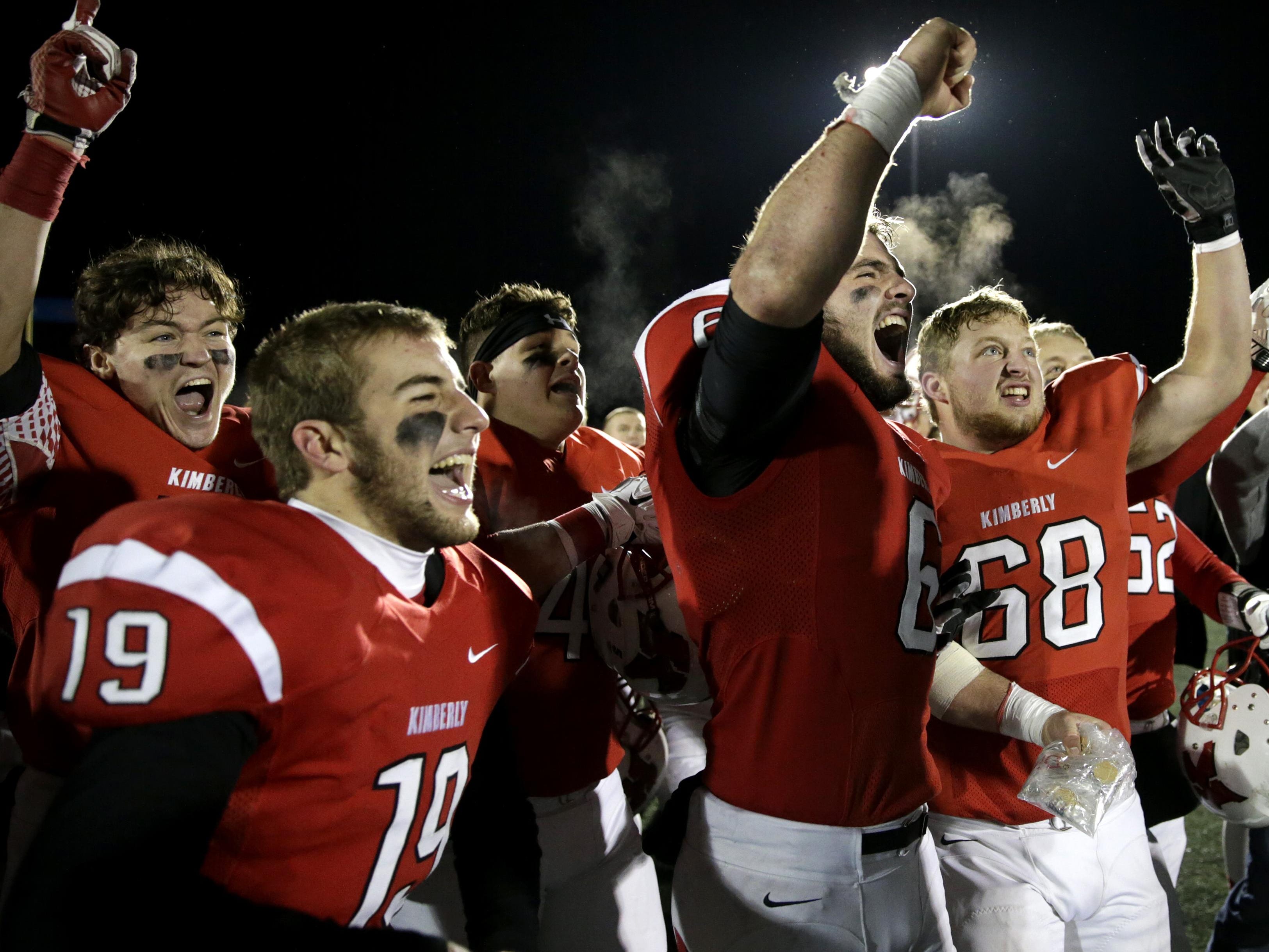Kimberly players including Nathan Janssen (19), Blair Mulholland (6) and Mickey Steger (68) celebrate after the Papermakers’ 49-20 win over Marquette Friday in a WIAA Division 1 state semifinal at Titan Stadium in Oshkosh.