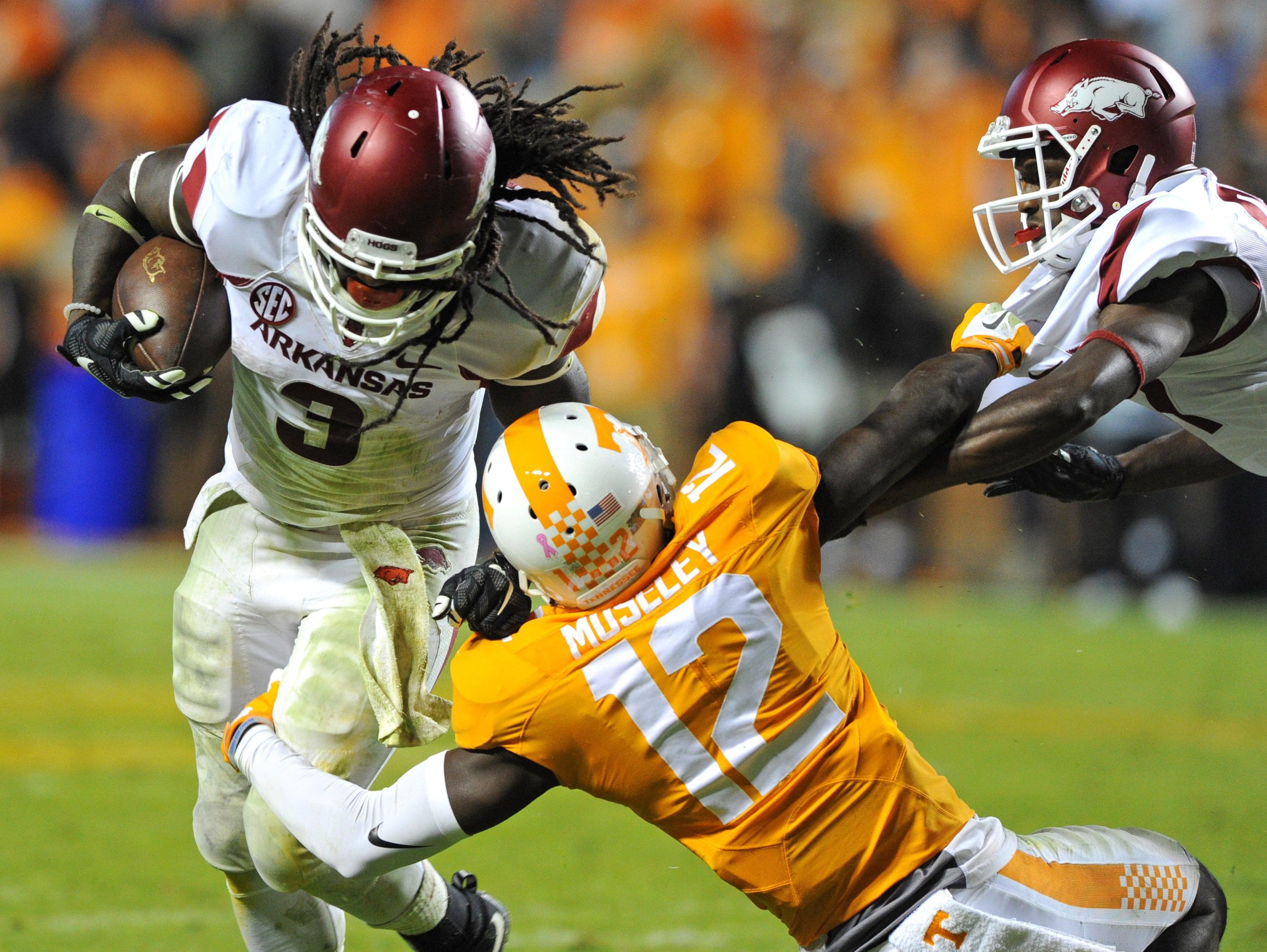 Arkansas running back Alex Collins (3) gets by Tennessee defensive back Emmanuel Moseley (12) with help from Arkansas wide receiver Dominique Reed during the second half at Neyland Stadium in Knoxville, Tenn. on Saturday.