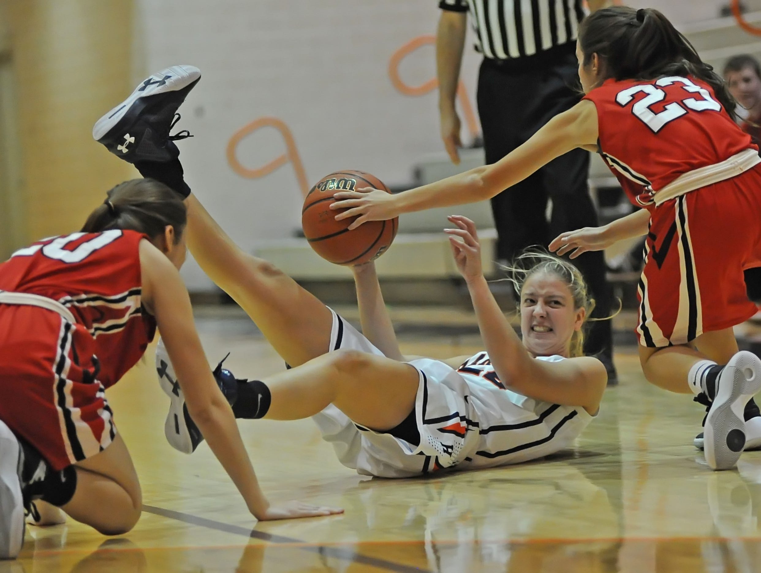 Harrison Senior Erica Rozenboom battles for control from the floor against Katie Hattabaugh and Maggie Gutwein during Friday night's J&C Hoops Classic at Harrison.