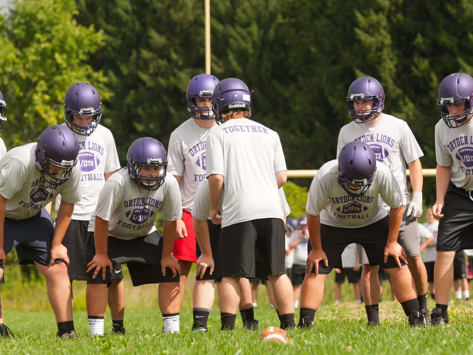 The Dryden High School football team prepares to run a play Monday morning during the first day of practice for fall sports.