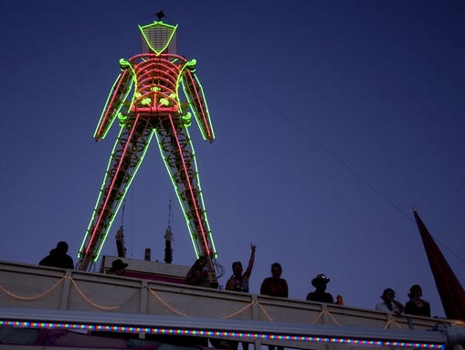 Burning Man participants stand under the Man Tuesday, Aug. 30, 2005. (Photo: RGJ file)