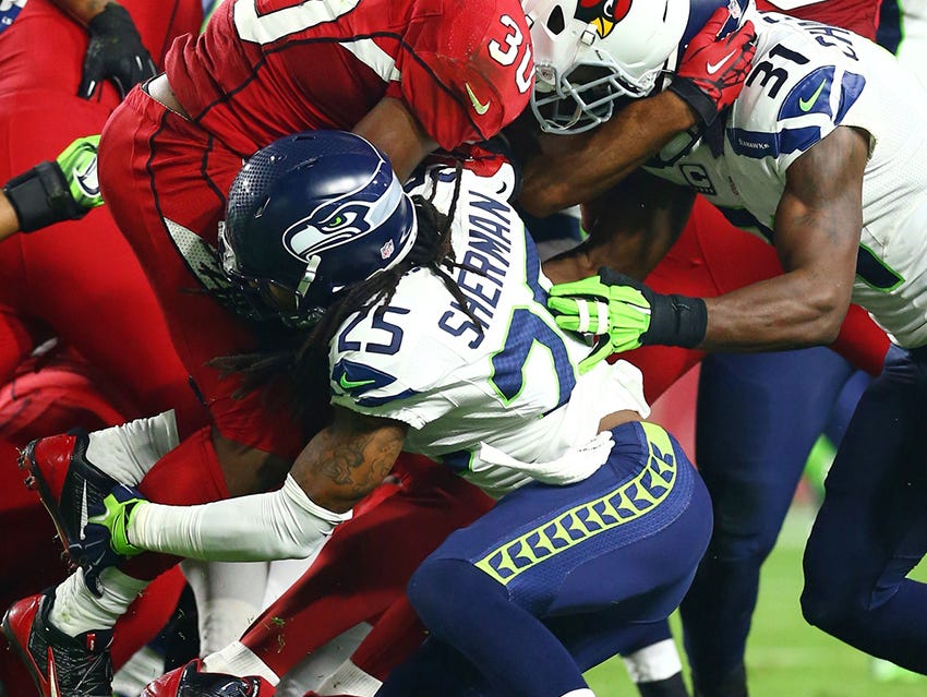 Richard Sherman of the Seattle Seahawks making a tackle leading with his shoulder.