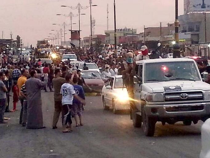 This authenticated handout photo shows militants parading down a main road in Mosul, Iraq. Days after Iraq's second-largest city fell to al-Qaeda-inspired fighters, some Iraqis are already returning to Mosul, lured back by insurgents offering cheap gas and food, restoring power and water and removing traffic barricades.