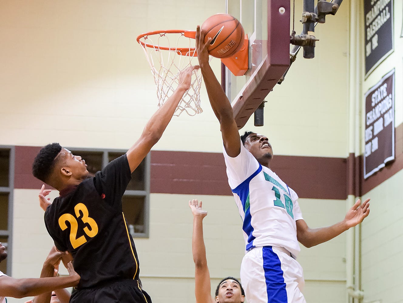 Lamar Hamrick (No. 10) of St. Georges Technical High School takes the ball to the net past the defense of Ish Valadez (No. 23) of Our Saviour Lutheran.