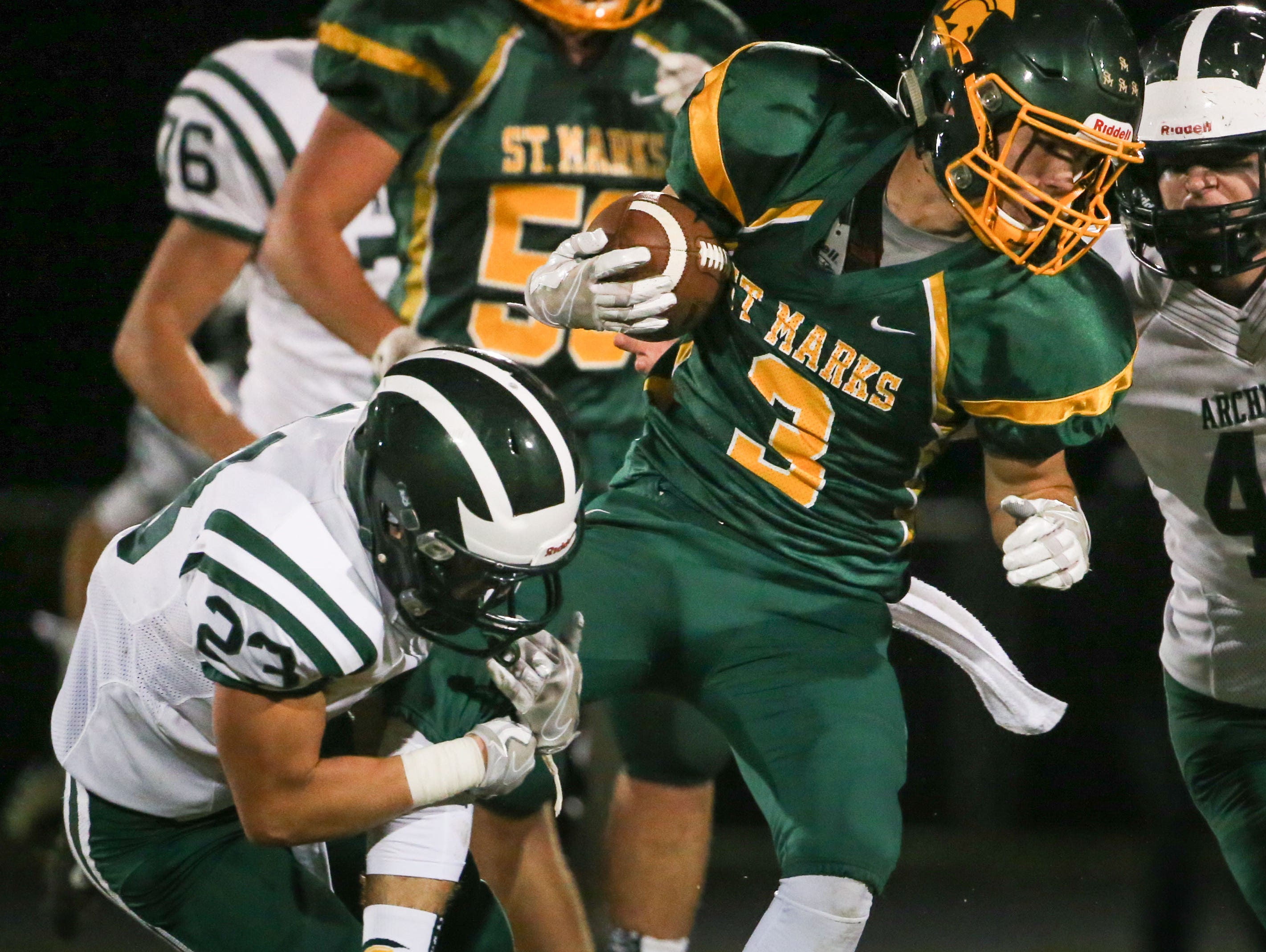 St. Mark's running back Maxwell Palmer is tied up by Archmere defensive back Patrick McVey in the second quarter of their game at St. Mark's Friday.