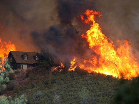 Flames from the Rocky Fire approach a house on July 31, 2015, in Lower Lake, Calif.