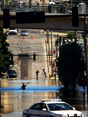 A kayaker paddles under the Shelby Street Bridge as