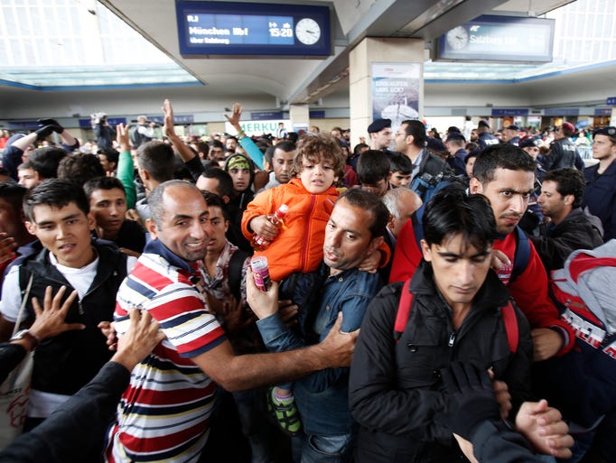 Migrants run to reach a train to Munich at the Westbahnhof