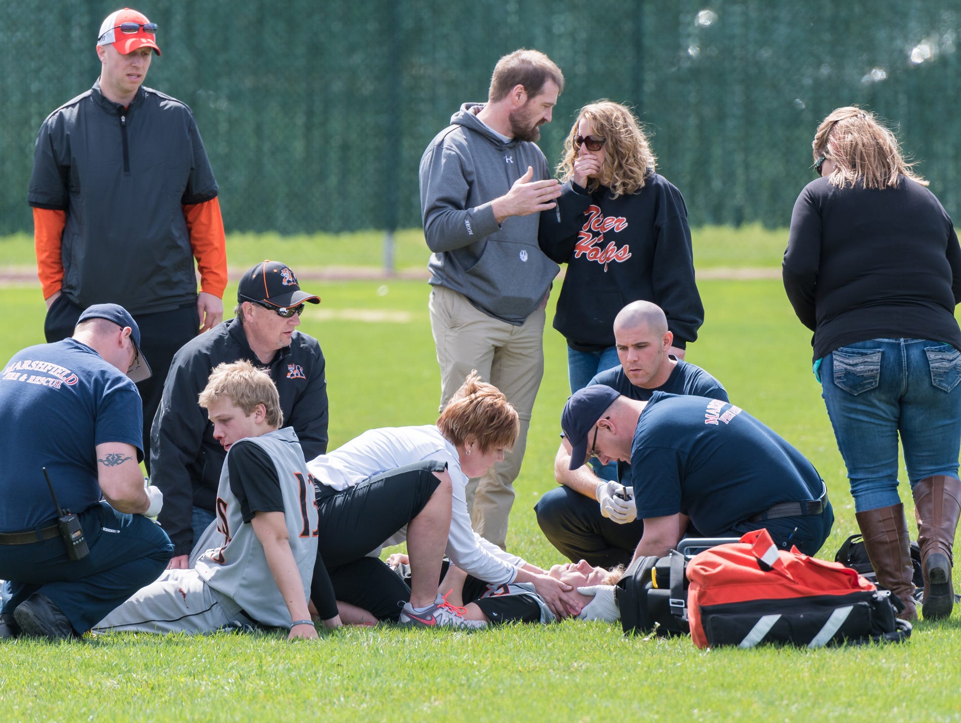 Marshfield High School baseball players Trevor Schwecke, 17, left, and Braden Bohman, right, receive treatment after they collided Saturday during a baseball game against Chippewa Falls at Jack Hackman Field in Marshfield.