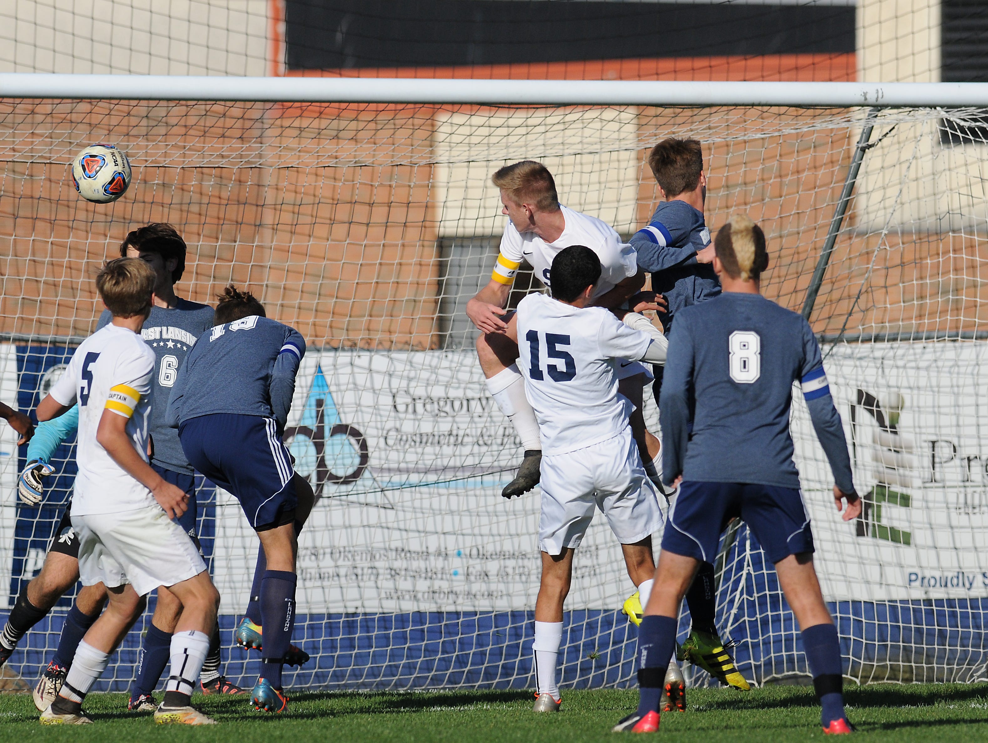 A DeWitt corner kick gets headed away from the goal in second half play in the D2 District Final Saturday, October 22, 2016. East Lansing won 2-1.