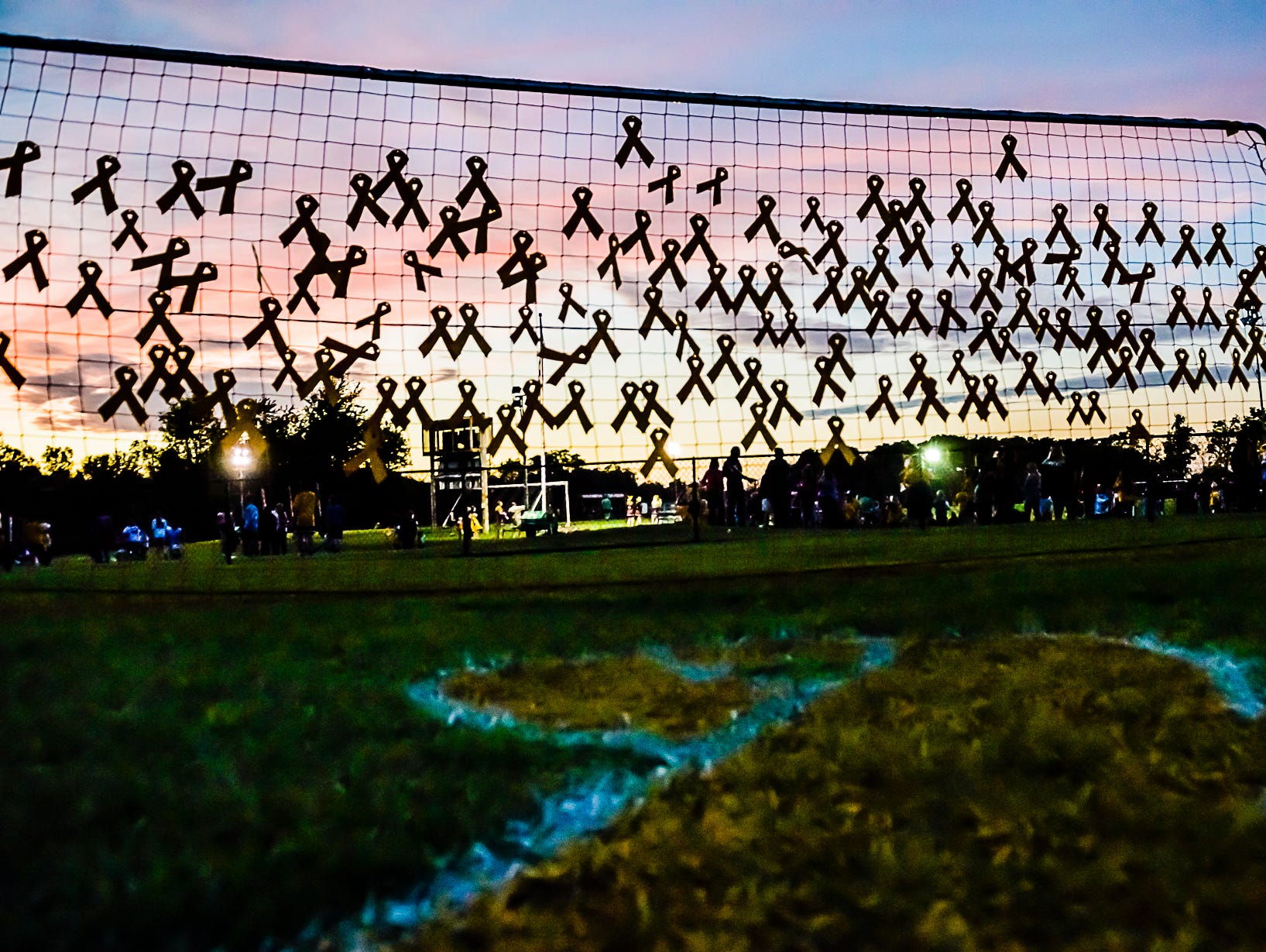 Yellow ribbons dedicated to cancer victims are hung on a net during the Mason/Okemos boys soccer game which was also a fundraiser for Compete for a Cause Saturday September 26, 2015 in Okemos.