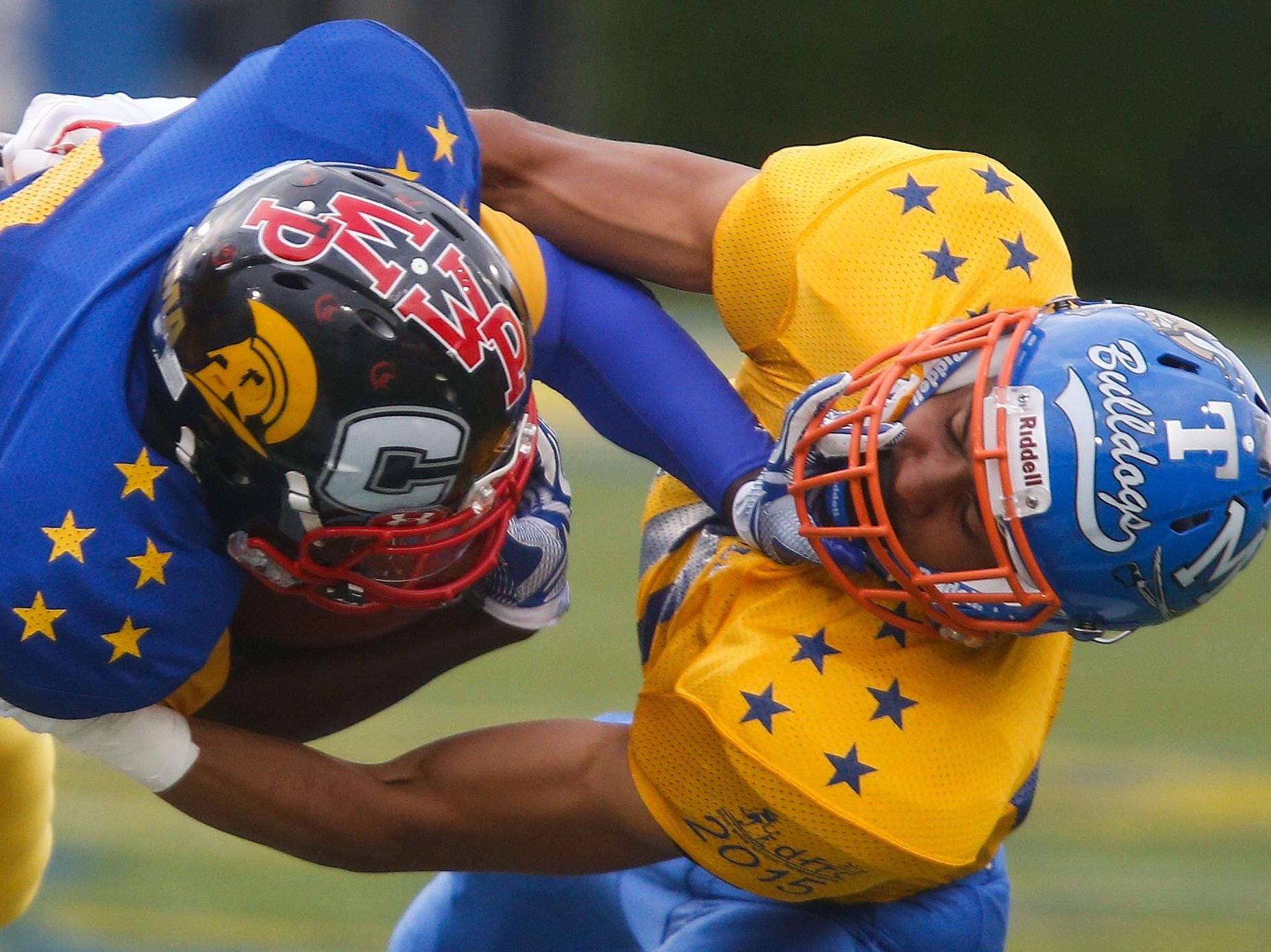 Blue's Reggie Carroll of Wiliam Penn (left) is brought down after a gain by Gold's Shane Leatherbury of Delmar High School in the first quarter of the DFRC Blue-Gold game Saturday.