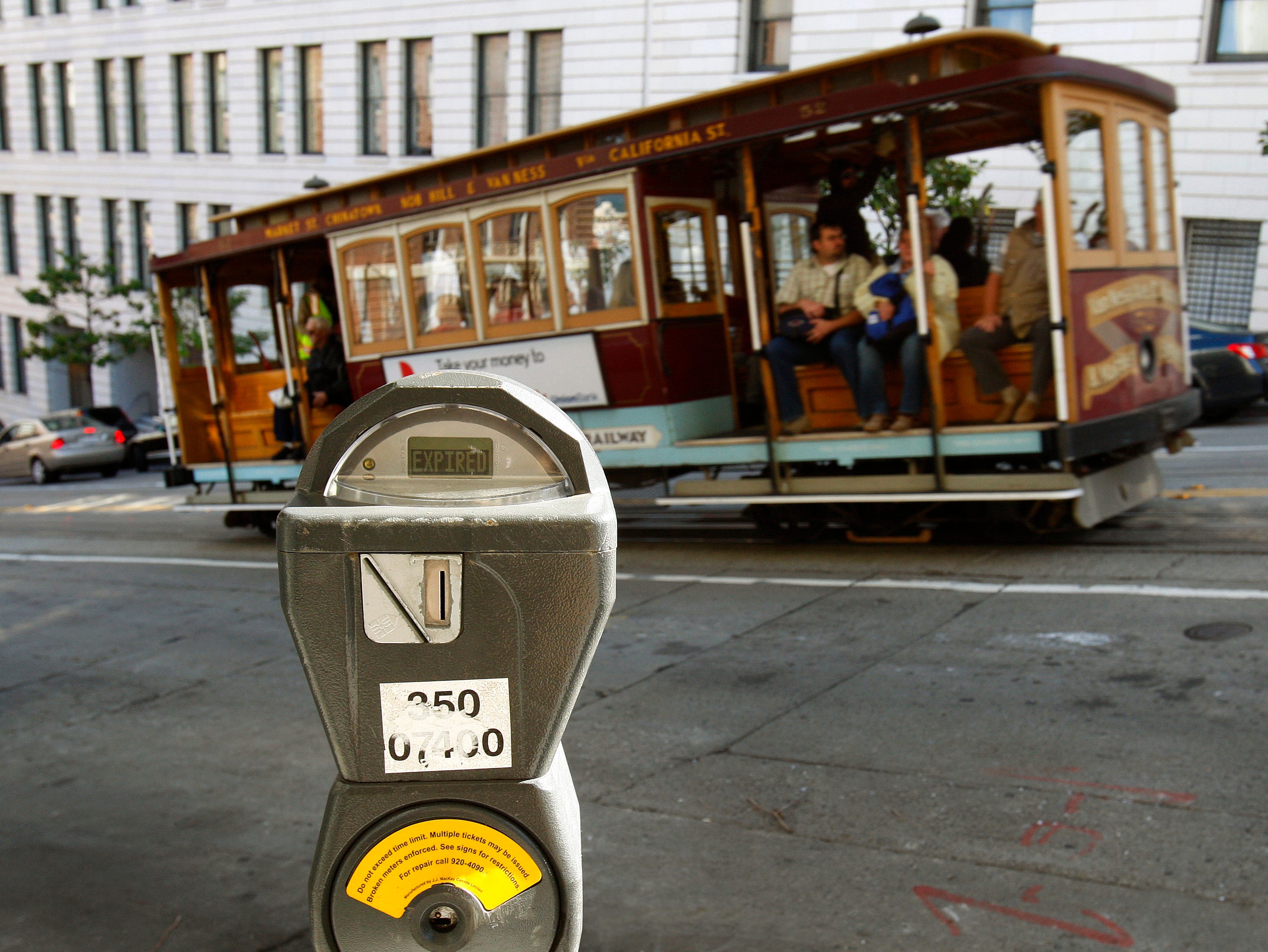 In this Oct. 27, 2009 file photo, a cable car passes a parking meter near San Francisco's financial district. San Francisco City Attorney Dennis Herrera on Monday, June 23, 2014 issued a cease-and-desist demand to a mobile app called Monkey Parking, 