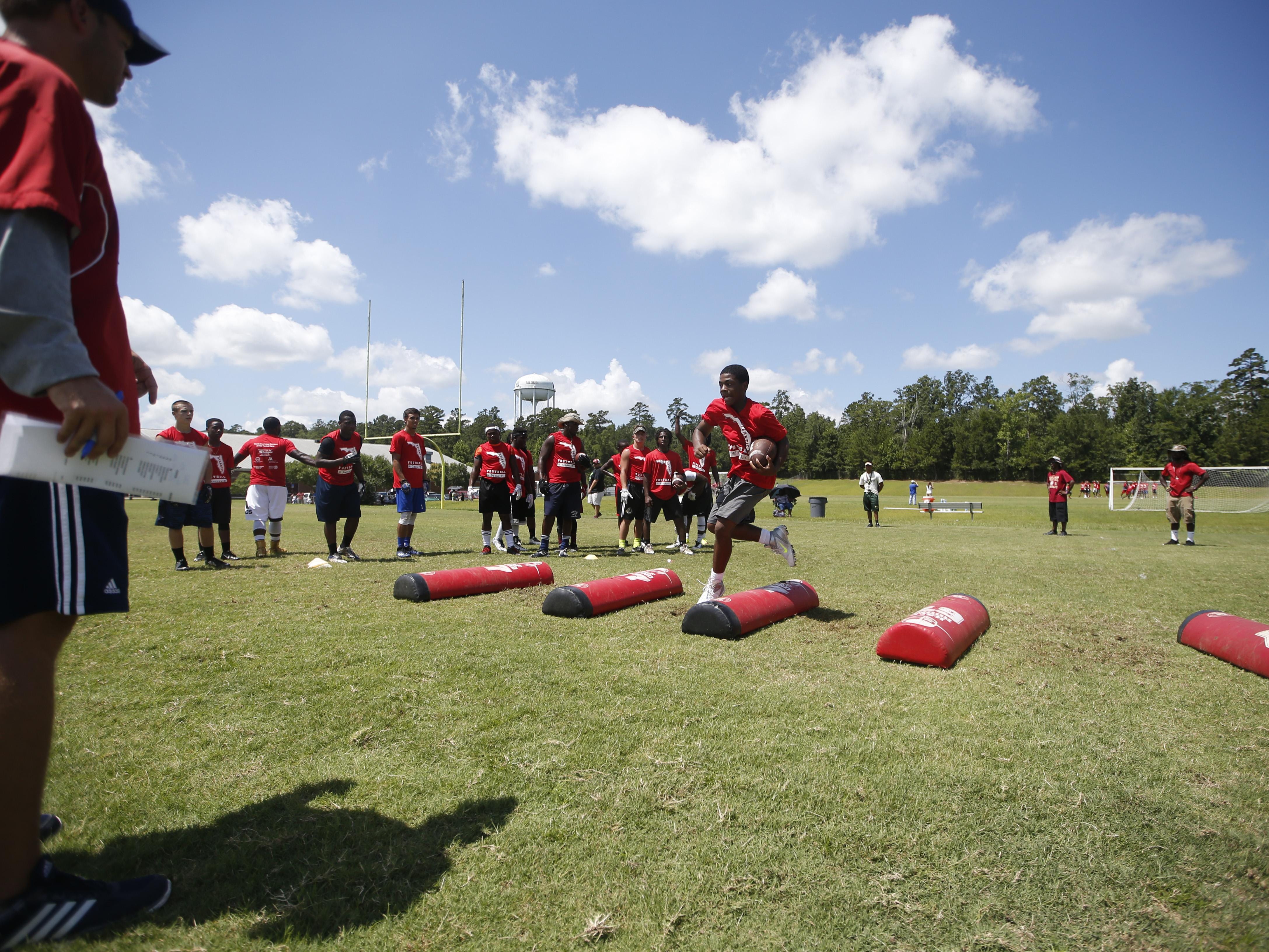 High school players run through drills during the Florida Atlantic Football Camp at Lawson Chiles High School on Friday.